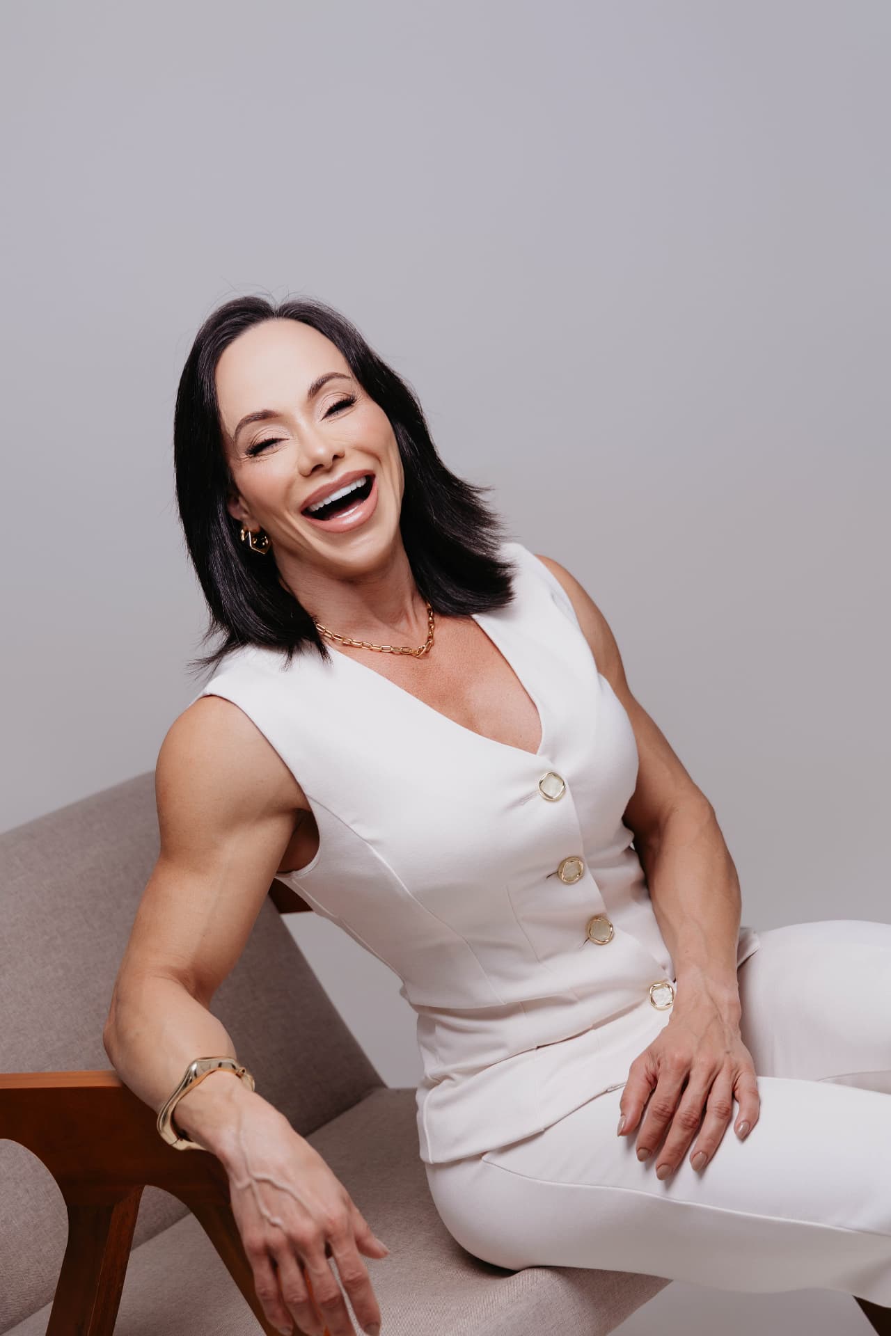 Gaby sorrindo sentada em poltrona